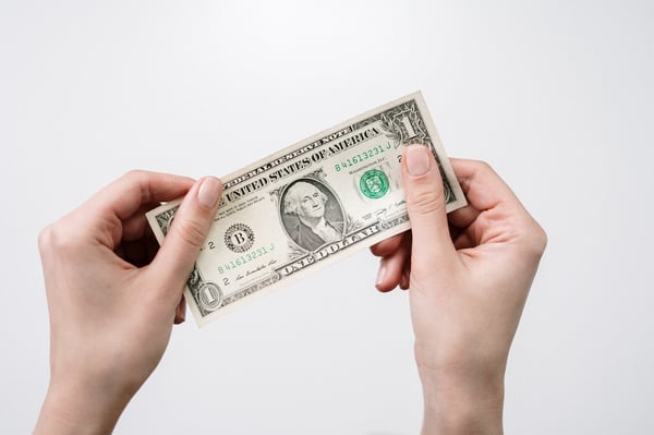 Hand holding a dollar bill