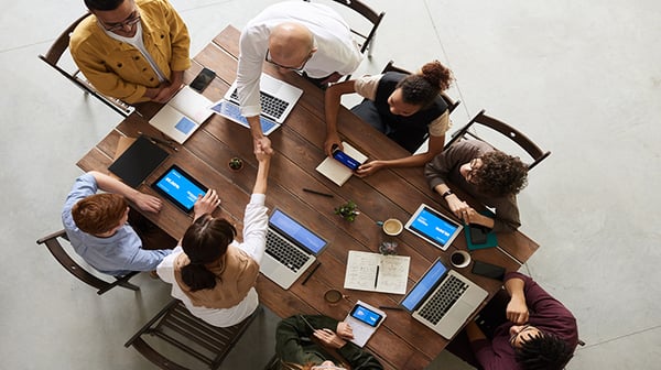 business_people_at_table_giving_handshakes